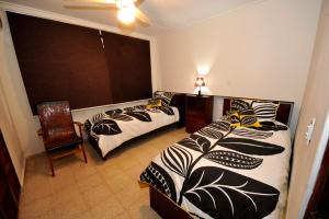 巴拿马城Totumas Lodge的一间卧室设有两张床、一把椅子和一个窗户。