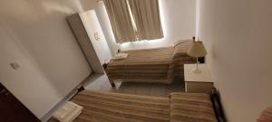 圣拉斐尔SAN EXPEDITO San Rafael的小房间设有两张床和窗户