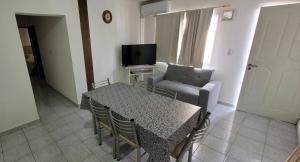 圣拉斐尔SAN EXPEDITO San Rafael的客厅配有桌子、椅子和电视