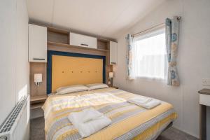 塞顿港Lisa Marie-Luxury Caravan-Seton Sands-8 Berth的一间卧室设有一张大床和一个窗户。