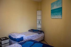 伊塔波阿Casa do Farol的一间设有两张床的客房,墙上挂着一张照片