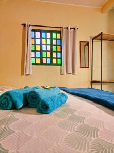 圣若热岛Canto da Coruja - ECOHOSPEDAGEM的一张带毛巾的床,有彩色玻璃窗