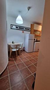 阿尔特杜尚Cantinho da Vila by Portus Alacer的厨房配有桌子和白色冰箱。