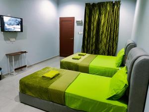 Kota BharuThe Marak Village KB - Mini Homestay的配有绿床单的客房内的两张床