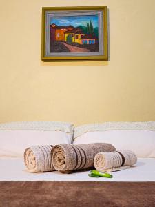 圣若热岛Canto da Coruja - ECOHOSPEDAGEM的一张床上有毛巾,墙上有绘画
