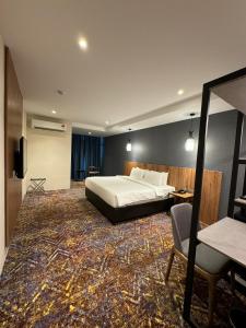 加影Le'genda Hotel的酒店客房,配有床、桌子和椅子