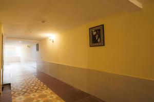 法里达巴德OYO Flagship Hotel Lazeeno的走廊上设有黄色的墙壁,上面有照片