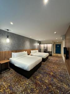 加影Le'genda Hotel的酒店客房设有两张床和电视。