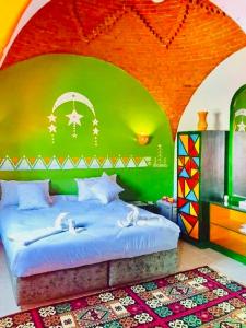 开罗Horus Mini Resort的一间卧室配有一张带绿色墙壁的床