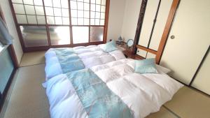 大川Okawaya - Vacation STAY 49372v的一间卧室配有三张床,铺有蓝色和白色的床单