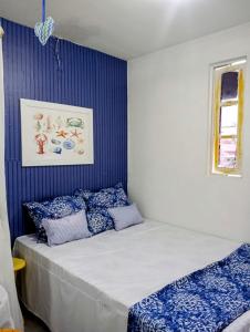 嘎林海斯港Chalés Caiçara Serrambi的一间卧室配有蓝色和白色床单