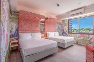 公主港巴拉望岛道夫酒店的酒店客房设有两张床和窗户。