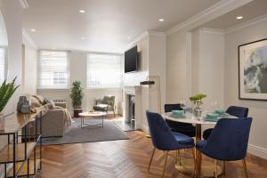 伦敦Deluxe Mayfair Luxury Apartment的客厅配有桌子和蓝色椅子