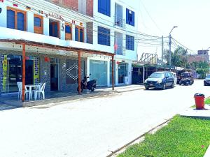 帕拉卡斯HOSPEDAJE JOSUE - paracas的停在大楼前的一条有摩托车的街道