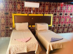 瓦迪拉姆Shakria Bedouin Life Camp的墙上的房间里设有两张床