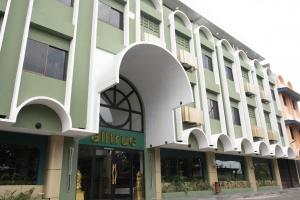 丹戎槟榔Alltrue Hotel Bintan - Tanjungpinang的白色绿色外墙的办公楼