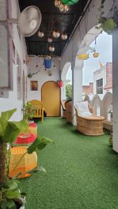马图拉Manavi Home Stay的一间铺有绿色地毯的客厅