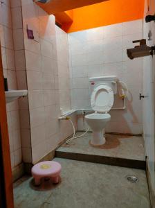 马图拉Manavi Home Stay的一间带卫生间和粉红色凳子的浴室