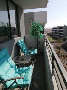 阿里卡Apartamento condominio Arica的大楼内的阳台配有桌椅