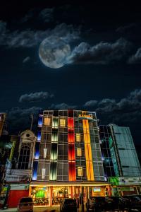 班达亚齐Parkside Alhambra Hotel Banda Aceh的一座月亮在天空后面的建筑