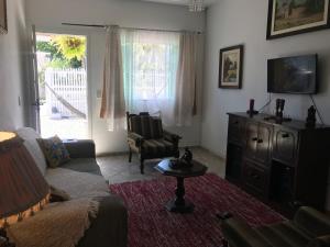 纳韦甘蒂斯Happy Guest House的客厅配有沙发、椅子和电视