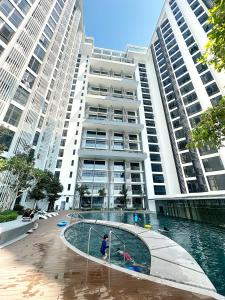 哥打京那巴鲁The Shore Kota Kinabalu City Centre by LW Suites的一座大型建筑,前面设有一个游泳池