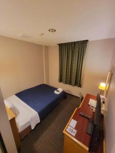 泉佐野海鸥酒店的配有一张床和一张书桌的酒店客房