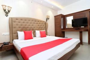 伯蒂亚拉OYO Heritage Corner的一间卧室配有一张带红色和白色枕头的大床
