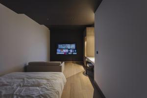 釜山阿班酒店的一间卧室配有一张床和一台平面电视