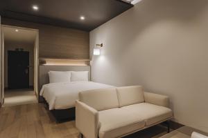 釜山阿班酒店的一间卧室配有一张床和一张沙发