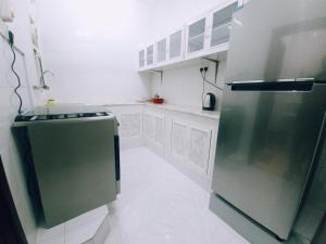 塞拉莱أجاويد Ajaweed的厨房配有不锈钢冰箱和白色橱柜