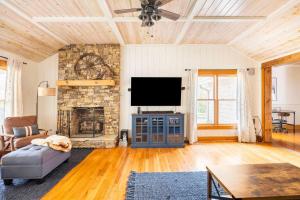 海兰兹Golden Acres Ranch Hot Tub+Gameroom+Creek & wifi的一间带电视和石制壁炉的客厅