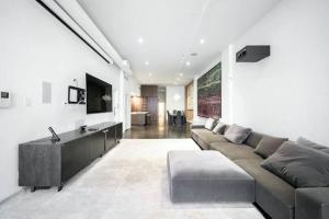 纽约Luxurious 3 BR/2BA Beautifully Renovated Loft的带沙发和电视的大型客厅