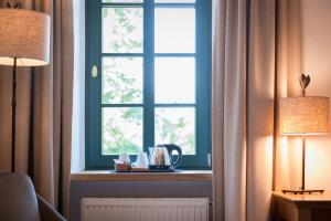 Niederzier伯格奥本多尔夫酒店的一间设有窗户的房间,配有一张桌子和两盏灯