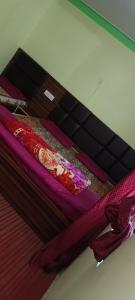 巴德里纳特Badrinath Dharmshala by Prithvi Yatra Hotel的床上铺有紫色床单