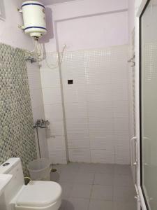巴德里纳特Badrinath Dharmshala by Prithvi Yatra Hotel的白色的浴室设有卫生间和淋浴。
