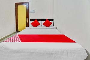 比拉斯布尔Collection O 45443 Hotel Suvidha的卧室配有带红色枕头的白色床