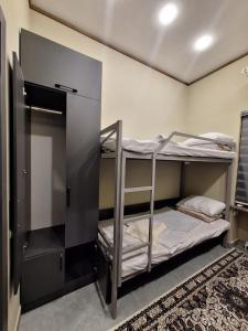 撒马尔罕Al Hilal Hostel的一间设有两张双层床和地毯的房间