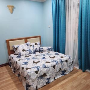 Kota BharuKB Homestay - Free WIFI的卧室内的一张床位,拥有蓝色的墙壁和蓝色的窗帘