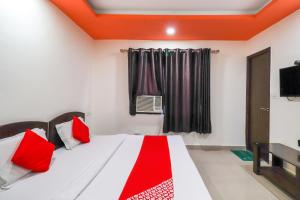 贾姆穆OYO Flagship 62748 Hotel Zeenat的一间卧室配有一张带红色枕头的床和一扇窗户