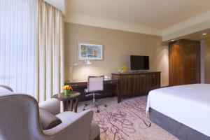 新加坡Sheraton Towers Singapore Hotel的配有一张床和一张书桌的酒店客房