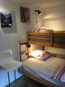 莱迪亚布勒雷Le Sapin的一间卧室配有两张双层床和椅子