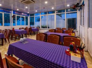 吉婆岛Cat Ba Hongkong Hotel的餐厅设有紫色桌椅和窗户