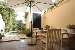 AnemómylosVilla Maxim in Corfu Town的庭院内桌椅和遮阳伞