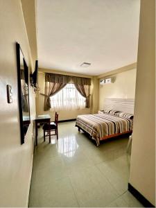 埃斯梅拉达斯Hotel Zulema Inn的一间卧室配有一张床、一张书桌和一个窗户。