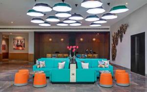 赖布尔Triton By Shyama Hotels & Resorts的大堂设有蓝色的沙发和橙色的椅子