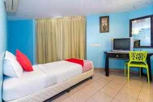 芙蓉Lotus Hotel Seremban Near Palm Mall & KPJ Seremban的一间卧室配有一张床和一张书桌及电视