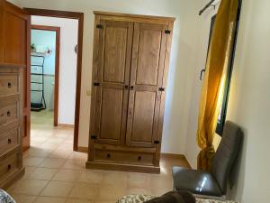 拉奥利瓦Casa Isabel的一间卧室配有木制橱柜和椅子
