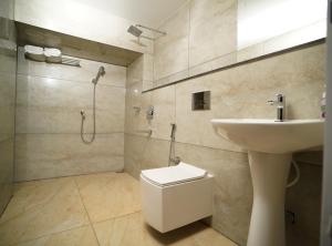 阿鲁法7 The Business Hotel的浴室配有卫生间、盥洗盆和淋浴。