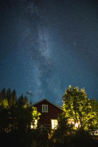 罗瓦涅米Kotatuli Forest Lodge的夜空里流 ⁇ 的房屋